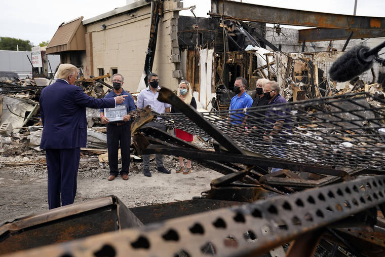 ASSOCIATED PRESS
                                President Donald Trump talked to business owners, today, as he toured an area damaged during demonstrations after a police officer shot Jacob Blake in Kenosha, Wis.