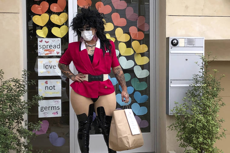 ASSOCIATED PRESS
                                Kochina Rude delivers food for customers in San Francisco on Aug. 28. A San Francisco drag show night club has taken the show on the road after having to close its doors due to the coronavirus pandemic. Oasis’ “Meals on Heals” is dispatching drag queens to deliver food, custom cocktails and socially-distant lip synch performances.