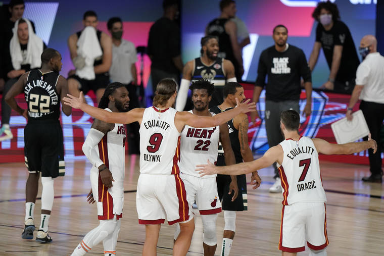 ASSOCIATED PRESS
                                Miami Heat’s Kelly Olynyk (9) and Jimmy Butler (22) react with teammates after the Heat beat the Milwaukee Bucks 116-114 in an NBA conference semifinal playoff basketball game today in Lake Buena Vista, Fla.