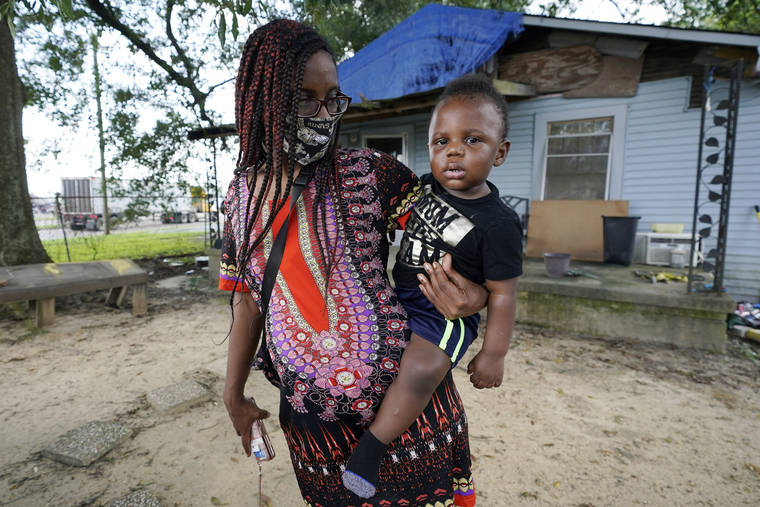 ASSOCIATED PRESS
                                Fakisha Fenderson and her son Tyler stood in the front yard of her parent’s home in Laurel, Miss., Monday. Fenderson’s weekly unemployment allotment is under $100, effectively eliminating her chance at receiving the $300 weekly supplement proposed by President Trump’s executive order.
