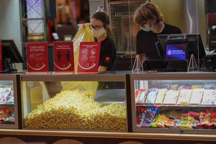 AP / AUG. 20
                                Concessions workers stock the bins with popcorn and other treats as the theatre opens for some of the first showings at the AMC theatre when it re-opened for the first time since shutting down at the start of the COVID-19 pandemic in West Homestead, Pa.