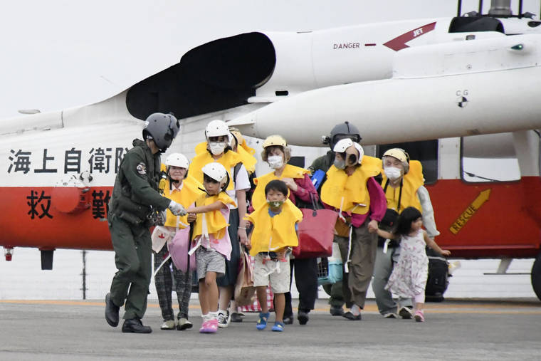 KYODO NEWS VIA AP
                                Residents of the islands arrive at a heliport in Kagoshima, southern Japan to take refuge ahead of a powerful typhoon. A powerful typhoon was barreling toward the southern cluster of Japanese Okinawa islands on Saturday, prompting warnings about torrential rainfall and fierce wind gusts.