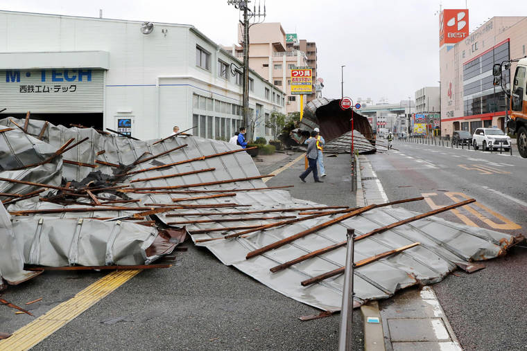 KYODO NEWS VIA AP
                                The roof of an auto repair garage is spread on sidewalk after Typhoon Haishen hit Fukuoka, southwestern Japan Monday. The second powerful typhoon to slam Japan in a week left people injured, damaged buildings, caused blackouts at nearly half a million homes and paralyzed traffic in southern Japanese islands before it headed to South Korea.