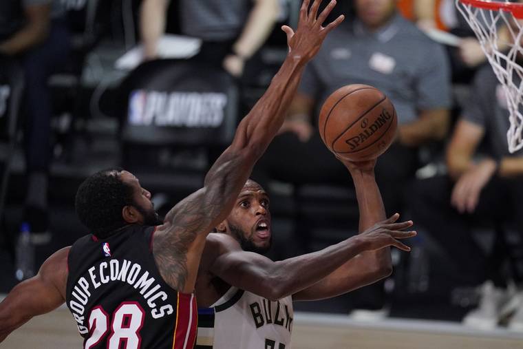 ASSOCIATED PRESS
                                Milwaukee Bucks’ Khris Middleton shoots past Miami Heat’s Andre Iguodala during the second half of an NBA conference semifinal playoff basketball game today in Lake Buena Vista, Fla.