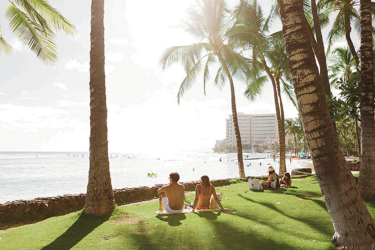 NEW YORK TIMES
                                Socially-distanced beachgoers take in the view in Waikiki on July 8. Can a post-­vaccine return to travel be smarter and greener than it was before March? Some in the tourism industry are betting on it.