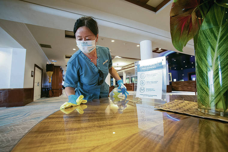 CINDY ELLEN RUSSELL / CRUSSELL@STARADVERTISER.COM
                                Outrigger Waikiki Beach Resort housekeeper Elain Peng wiped down a table at the hotel.