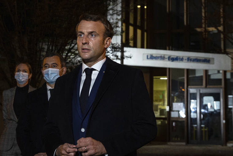 ASSOCIATED PRESS
                                French President Emmanuel Macron, flanked by French Interior Minister Gerald Darmanin, second left, speaks in front of a high school Friday in Conflans Sainte-Honorine, northwest of Paris, after a history teacher who opened a discussion with high school students on caricatures of Islam’s Prophet Muhammad was beheaded.