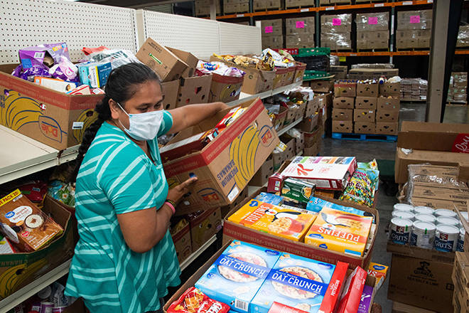 CRAIG T. KOJIMA /CKOJIMA@STARADVERTISER.COM
                                Kathleen Roberts, from the food pantry at Aiea Seventh Day Adventist Church, gathers up boxes of canned goods today at Hawaii Foodbank’s warehouse in Mapunapuna. Cutter Mazda donated $100,000 to the Foodbank today.