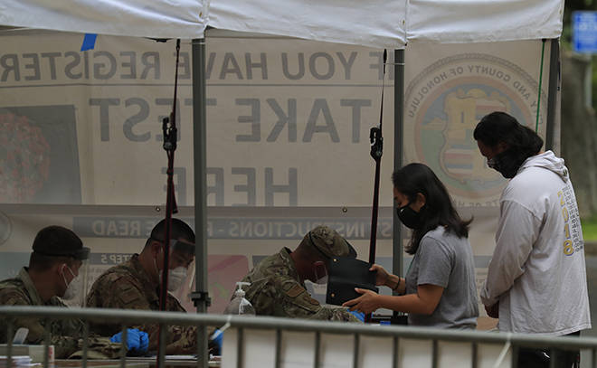 JAMM AQUINO / OCT. 22
                                Hawaii National Guardsmen check in people walking in for COVID-19 testing on Thursday at the Waikiki Shell in Waikiki.