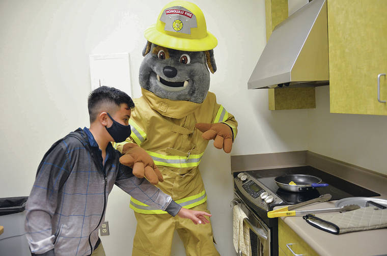HONOLULU FIRE DEPARTMENT 
                                Above, Poki, the Honolulu Fire Department safety mascot, demonstrates HFD’s recommendation that children and pets stay at least 3 feet away from a hot stove.