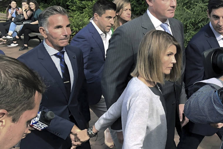 ASSOCIATED PRESS
                                Lori Loughlin departs federal court in Boston with her husband, Mossimo Giannulli, left, after a hearing in a nationwide college admissions bribery scandal in 2019. Giannulli has reported to prison to begin serving his five-month sentence for bribing his daughters’ way into college.