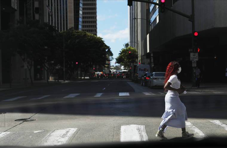 JAMM AQUINO / JAQUINO@STARADVERTISER.COM
                                A mask-wearing woman crosses Bishop Street on Tuesday in Honolulu. Hawaii government leaders and health officials continue to encourage the public to wear masks in public, practice social distancing and avoid social gatherings to help curb the spread of COVID-19.