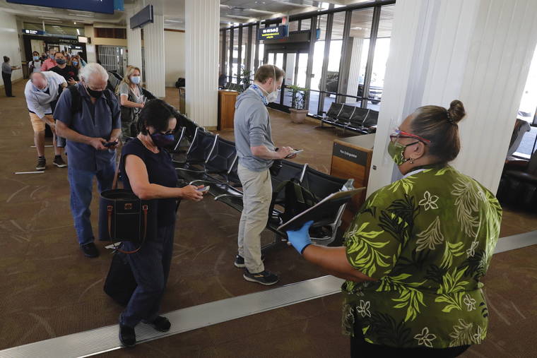 JAMM AQUINO / OCT. 15
                                Travelers take out their smartphones with QR codes as they wait in line to be screened after arriving on transpacific flights at the Daniel K. Inouye International Airport.