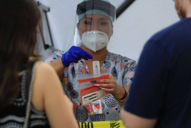 JAMM AQUINO / JAQUINO@STARADVERTISER.COM
                                Kahu Malama nurse Maile Toyama demonstrates how to self-administer a COVID-19 test at the Neal Blaisdell during today’s final free COVID-19 surge testing.
