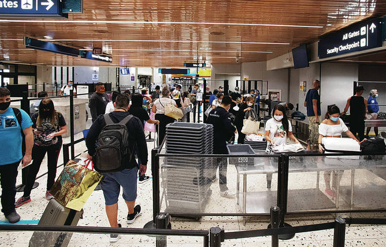 CINDY ELLEN RUSSELL / CRUSSELL@STARADVERTISER.COM
                                Travelers passed through the Terminal 1 security checkpoint Sunday at Daniel K. Inouye International Airport.