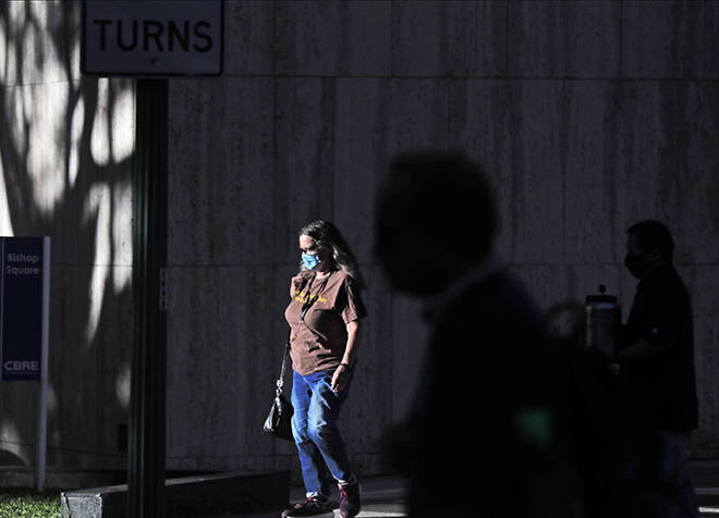 JAMM AQUINO / OCT. 30
                                Mask-wearing pedestrians walk along Bishop Street in Honolulu last month. Government and health officials continue to urge the public to wear masks and practice social distancing to help prevent the spread of the coronavirus.