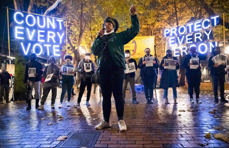 ERIKA SCHULTZ/THE SEATTLE TIMES VIA AP / NOV. 4
                                Travonna Thompson-Wiley, with the Black Action Coalition, speaks at the “Count Every Vote - Protect Every Person,” rally and march in Occidental Park in Seattle. The coalition demanded that every vote is counted and orderly transition of power, as well as the elimination the Electoral College. The acrimonious 2020 presidential election is spotlighting an effort to get rid of the current Electoral College system and instead elect America’s leader by a national popular vote. Advocates hope it’ll be in place by the next presidential election.