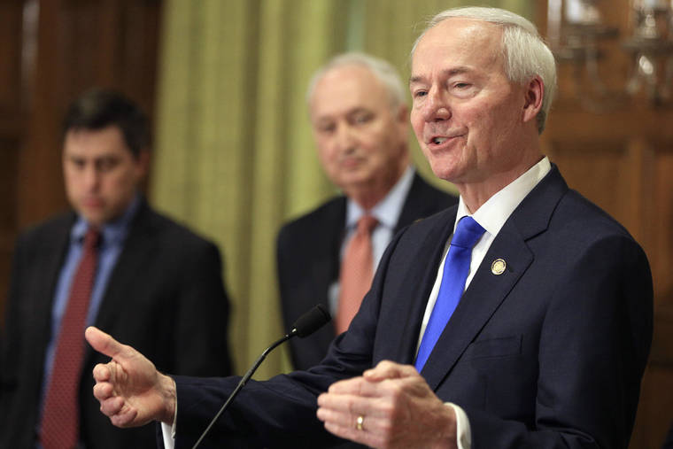 ASSOCIATED PRESS
                                Gov. Asa Hutchinson, right, speaks along with Larry Walther, middle, Secretary of the Department of Finance and Administration and Jake Bleed, state budget director in Little Rock, Ark., in March.