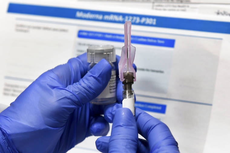 ASSOCIATED PRESS / JULY 27
                                A nurse prepares a shot as a study of a possible COVID-19 vaccine, developed by the National Institutes of Health and Moderna Inc., gets underway in Binghamton, N.Y.
