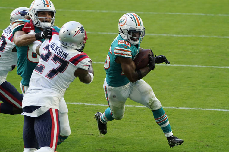 ASSOCIATED PRESS
                                Miami Dolphins running back Salvon Ahmed (26) runs for a two-point conversion during the second half of an NFL football game against the New England Patriots today in Miami Gardens, Fla.