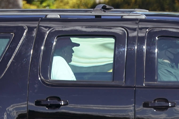 ASSOCIATED PRESS
                                President Donald Trump rides in a motorcade vehicle as he departs Trump International Golf Club, today in West Palm Beach, Fla.