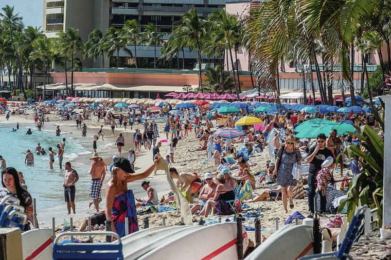 DENNIS ODA / FEB. 27
                                Visitor arrivals and spending posted solid growth in January before tourism started to feel the impacts of the coronavirus. Crowds of tourists sunbathe and swim on Waikiki Beach.