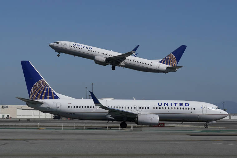 ASSOCIATED PRESS
                                A United Airlines airplane took off over a plane on the runway at San Francisco International Airport in San Francisco on Oct. 15.
