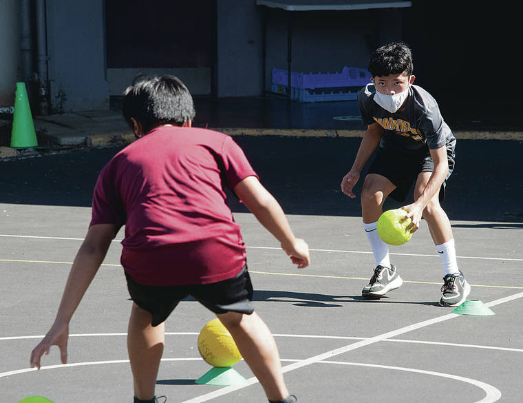 CRAIG T. KOJIMA/CKOJIMA@STARADVERTISER.COM
                                Students at Maryknoll School wear masks while taking part in a physical education class.
