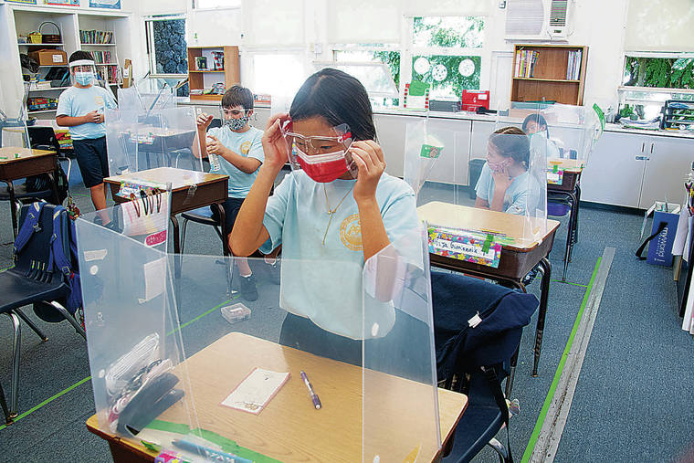 CRAIG T. KOJIMA/CKOJIMA@STARADVERTISER.COM 
                                Catholic schools managed to offer in-person classes this fall despite the pandemic. Above, Soji Stephanelli adjusts her mask during a fourth grade class at Mary, Star of the Sea School.