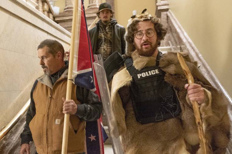 ASSOCIATED PRESS / JAN. 6, 2021
                                Insurrectionists loyal to President Donald Trump, including Aaron Mostofsky, right, and Kevin Seefried, left, walk down the stairs outside the Senate Chamber in the U.S. Capitol, in Washington on Jan. 6. More than 125 people have been arrested so far on charges related to the violent insurrection at the U.S. Capitol, where a Capitol police officer and four others were killed.