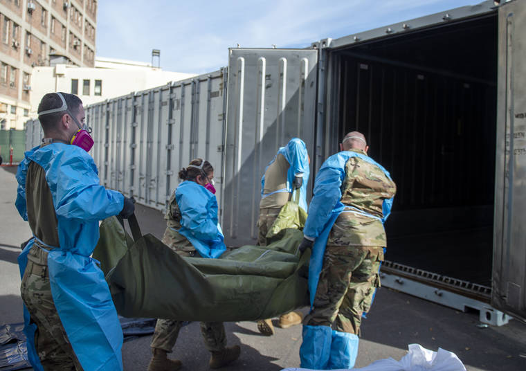 ASSOCIATED PRESS
                                This photo provided Tuesday by the Los Angeles County Department of Medical Examiner-Coroner shows National Guard members assisting with processing COVID-19 deaths and placing them into temporary storage outside the coroner’s office. About 500 people are dying each day in California because of the coronavirus.