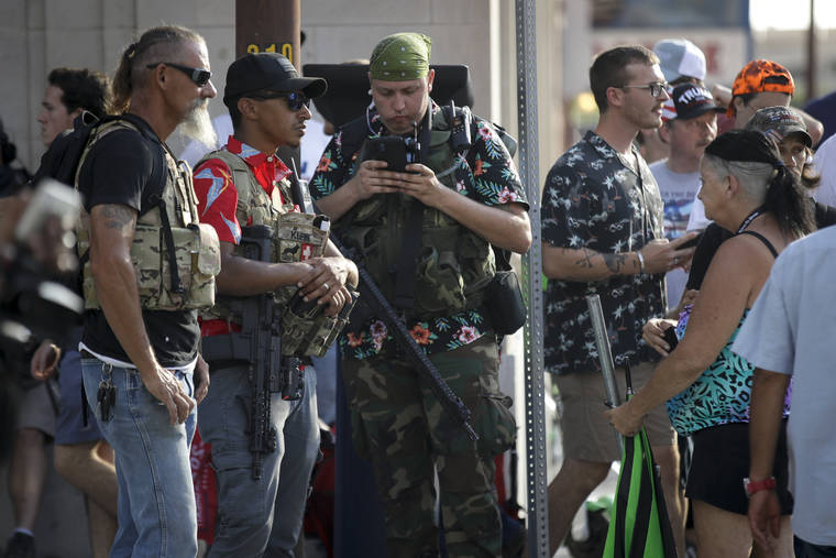 ASSOCIATED PRESS / JUNE 20
                                Gun-carrying men wearing Hawaiian print shirts associated with the boogaloo movement watch a demonstration near where President Trump had a campaign rally in Tulsa, Okla. People following the anti-government boogaloo movement, which promotes violence and a second U.S. civil war, have been showing up at protests across the nation armed and wearing tactical gear. But the movement has also adopted an unlikely public and online symbol: Aloha shirts.