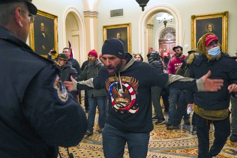 ASSOCIATED PRESS
                                Trump supporters, including Doug Jensen, center, confronted U.S. Capitol Police in the hallway outside of the Senate chamber, Jan. 6, at the Capitol in Washington. Some followers of the QAnon conspiracy theory are now turning to online support groups and even therapy to help them move on, now that it’s clear Donald Trump’s presidency is over.