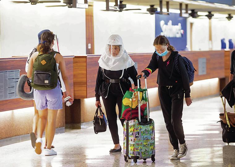 A traveler wore a hooded system as personal protective equipment Sunday at Daniel K. Inouye International Airport.