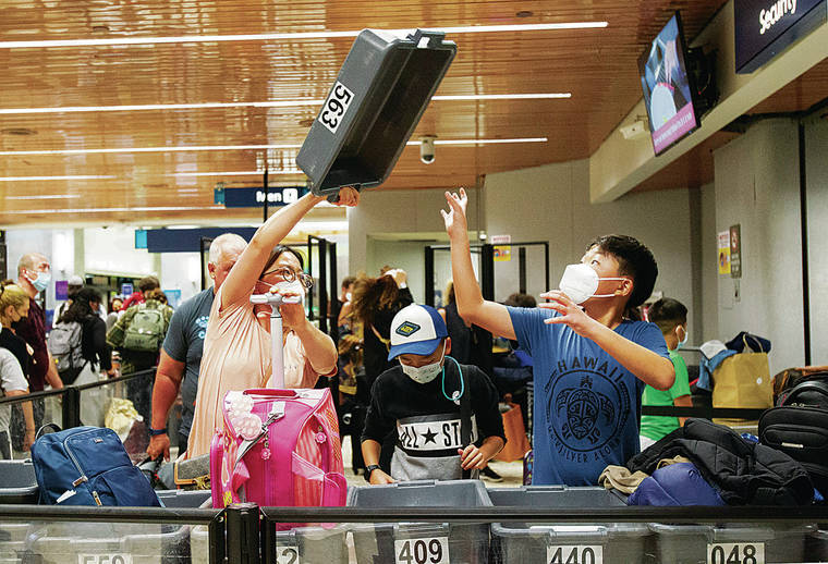 CINDY ELLEN RUSSELL / CRUSSELL@STARADVERTISER.COM
                                Travelers placed their personal belongings in bins Sunday at the Terminal 1 security checkpoint in Daniel K. Inouye International Airport.