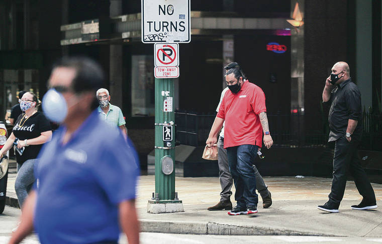 JAMM AQUINO / JAQUINO@STARADVERTISER.COM
                                Pedestrians wearing masks Monday crossed at the intersection of Bishop and Hotel streets.