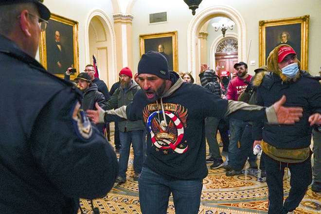 ASSOCIATED PRESS
                                Trump supporters gesture to U.S. Capitol Police in the hallway outside of the Senate chamber at the Capitol in Washington today.