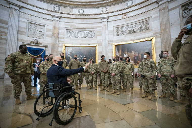 ASSOCIATED PRESS
                                Rep. Brian Mast, R-Fla., left, visits with National Guard troops who are helping with security at the Capitol Rotunda in Washington on Wednesday.