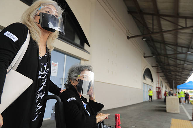 JAMM AQUINO / JAQUINO@STARADVERTISER.COM
                                Corinne Shinn, left, and mother Mavis Taniguchi, 85, wait for their transportation after both receiving the COVID-19 vaccine at the first mass COVID-19 vaccination clinic at Pier 2 on Monday in Honolulu. Over 27,000 are expected to receive the Pfizer/Biotech COVID-19 vaccine at the site, which is being overseen by Hawaii Pacific Health.