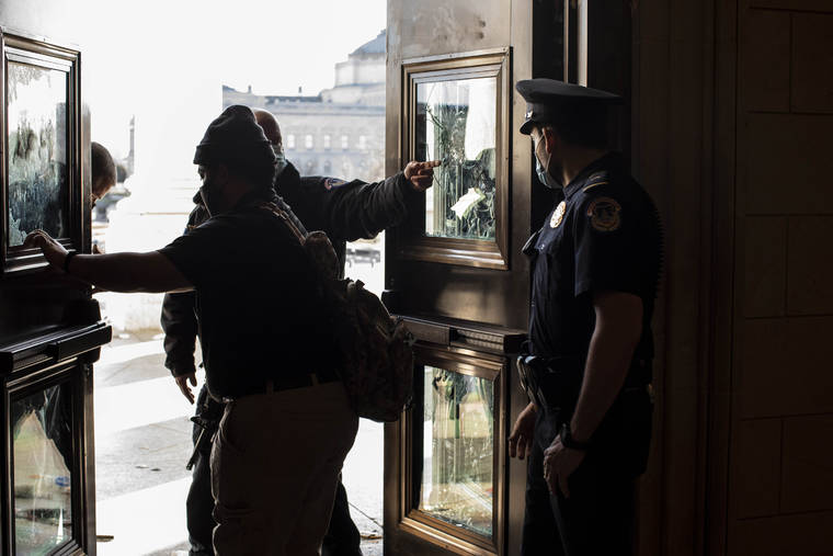 NEW YORK TIMES
                                Capitol police and contractors survey damage to an entrance at the Capitol in Washington on Thursday.
