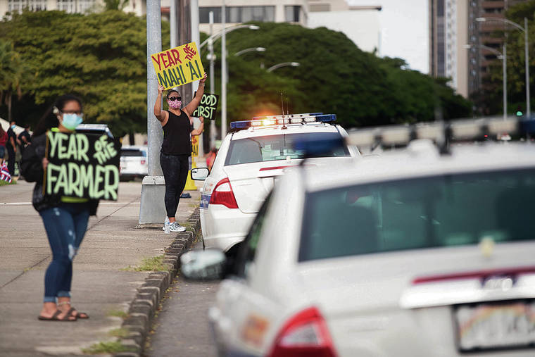 CINDY ELLEN RUSSELL / CRUSSELL@STARADVERTISER.COM
                                Above, Aileen Witt held a sign along Beretania Street at the state Capitol on Wednesday in support of local farmers.