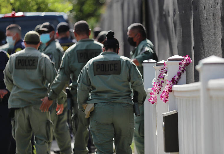 JAMM AQUINO/JAQUINO@STARADVERTISER.COM 
                                Two orchid lei hung on the fence as Honolulu police officers departed after paying their respects Tuesday at 3015 Hibiscus Drive.
