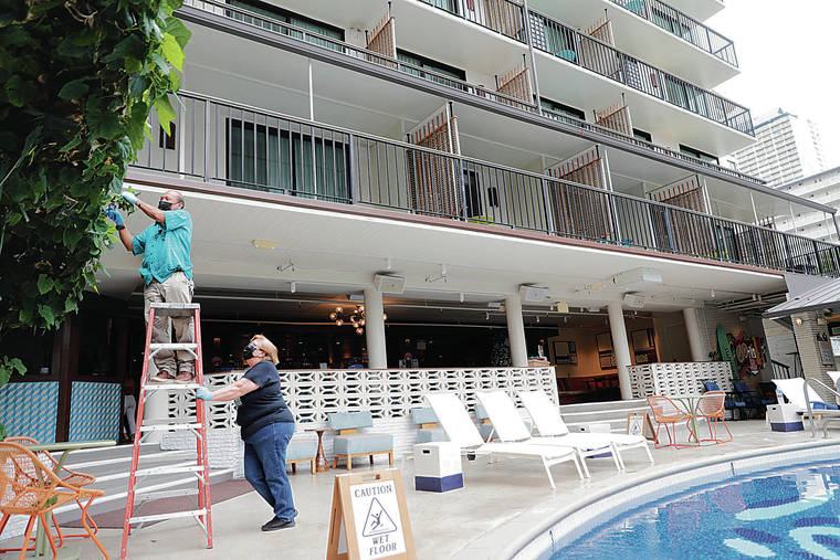 JAMM AQUINO / JAQUINO@STARADVERTISER.COM
                                Maintenance supervisor Nelson Antalan, left, trimmed leaves from the trellis in the lobby area as Pam Kaina, director of housekeeping and maintenance, held the ladder steady on Friday at the Surfjack Hotel & Swim Club in Waikiki.