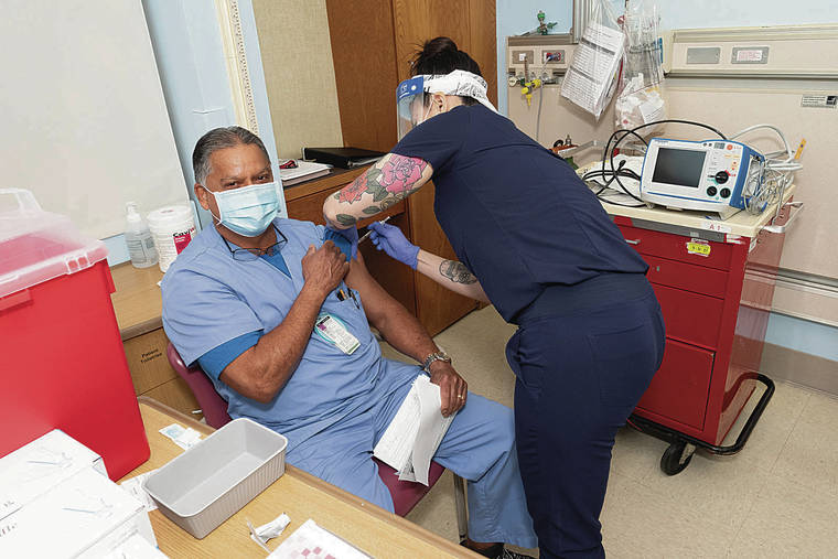 COURTESY KAISER PERMANENTE
                                Clarence Rodrigues, a respiratory therapist, receives the COVID-19 vaccine.