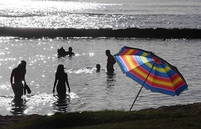 CINDY ELLEN RUSSELL / DEC. 31, 2020
                                Silhouetted beachgoers wade into the waters of Waikiki.