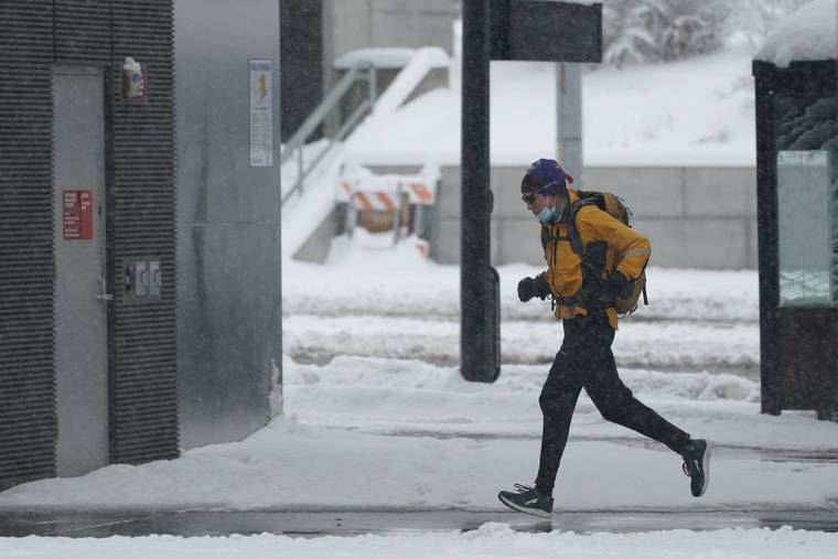 ASSOCIATED PRESS
                                A person runs in the snow Saturday on the University of Washington campus in Seattle. Winter weather was expected to continue through the weekend in the region.