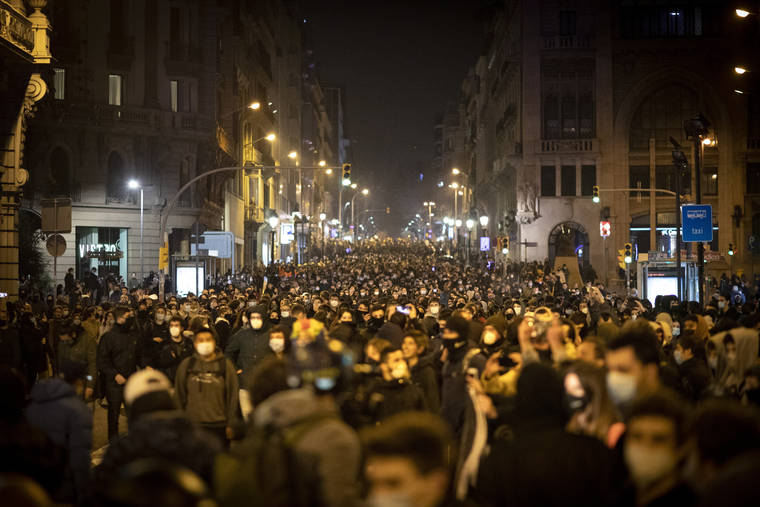 ASSOCIATED PRESS / FEB. 19
                                Demonstrators march during a protest condemning the arrest of rap singer Pablo Hasél in Barcelona, Spain. Violent street protests over the imprisonment of a rapper have erupted for a fourth straight night in Spain. Police in the northeastern region of Catalonia said some protesters pelted officers with bottles, stones, fireworks and paint on Friday.
