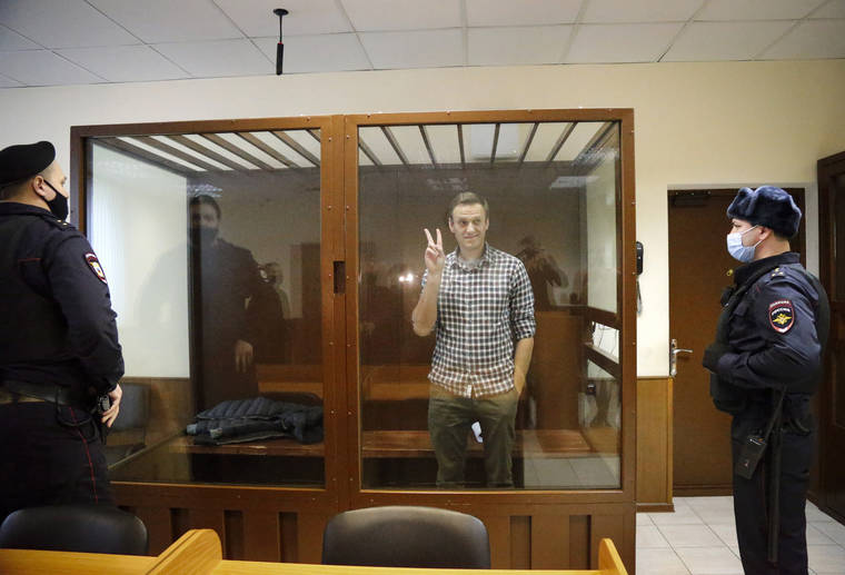 ASSOCIATED PRESS
                                Opposition leader Alexei Navalny stands in a cage in the Babuskinsky District Court in Moscow, Russia. Two trials against Navalny are being held Moscow City Court one considering an appeal against his imprisonment in the embezzlement case and another announcing a verdict in the defamation case.