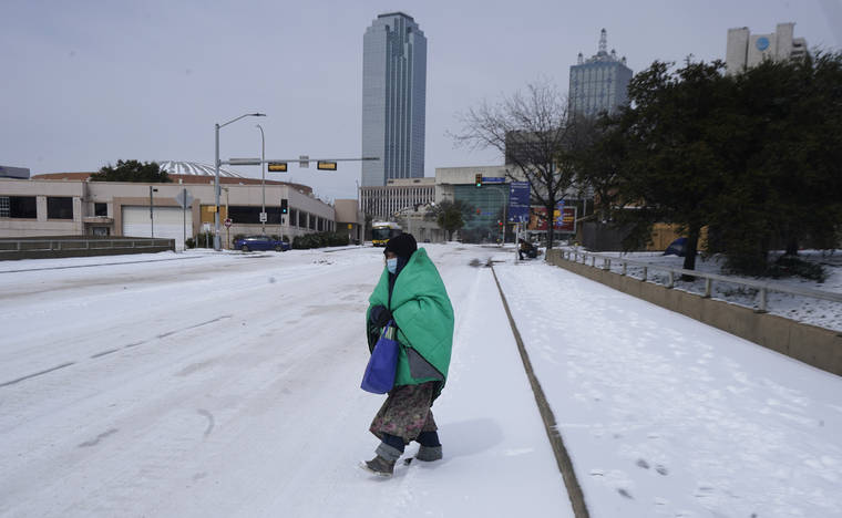 ASSOCIATED PRESS
                                A woman wrapped in a blanket crosses the street near downtown Dallas on Feb. 16. As temperatures plunged and snow and ice whipped the state, much of Texas’ power grid collapsed, followed by its water systems. Tens of millions huddled in frigid homes that slowly grew colder or fled for safety.
