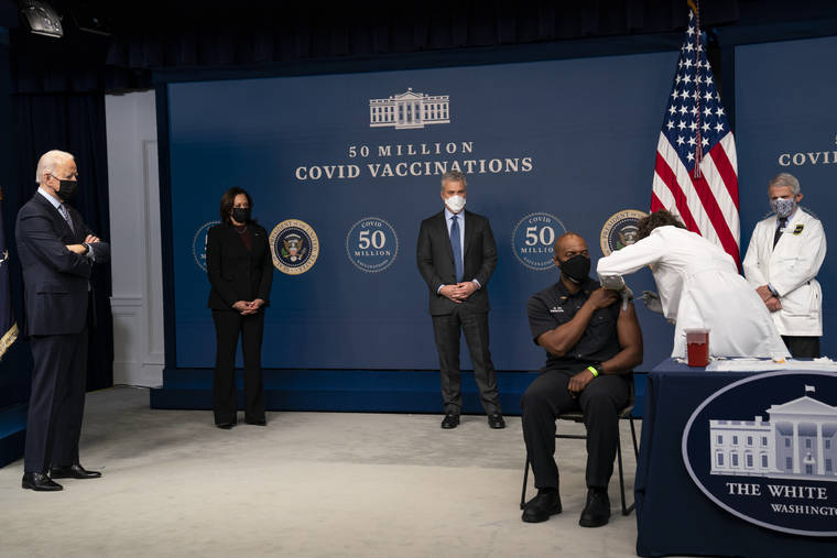 ASSOCIATED PRESS
                                President Joe Biden looks on as Washington DC firefighter and EMT Gerald Burn receives a vaccination, during an event to commemorate the 50 millionth COVID-19 shot, in the South Court Auditorium on the White House campus in Washington. From left, Biden, Vice President Kamala Harris, White House COVID-19 Response Coordinator Jeff Zients, Burn, registered nurse Elizabeth Galloway, and director of the National Institute of Allergy and Infectious Diseases Dr. Anthony Fauci.